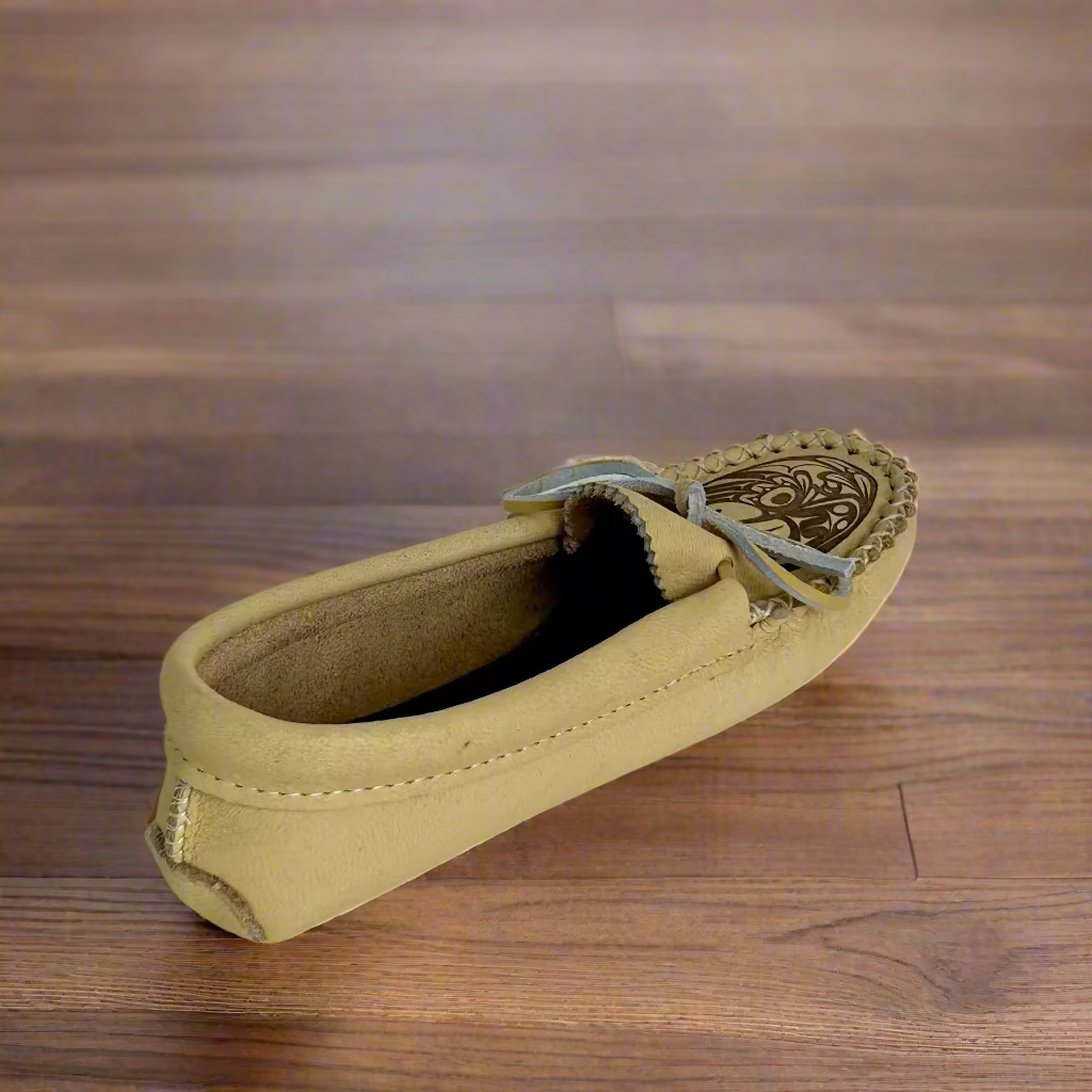 Beige loafer shoe with decorative sole on a white background