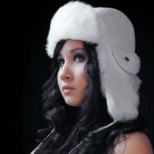 Person wearing a white fur hat against a dark background