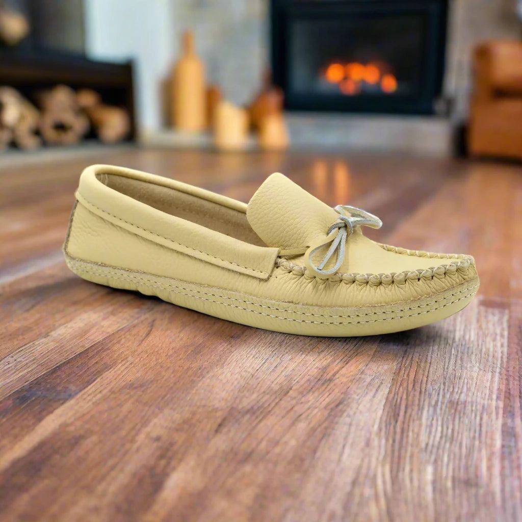 Yellow loafer shoe on a wooden floor with a fireplace in the background