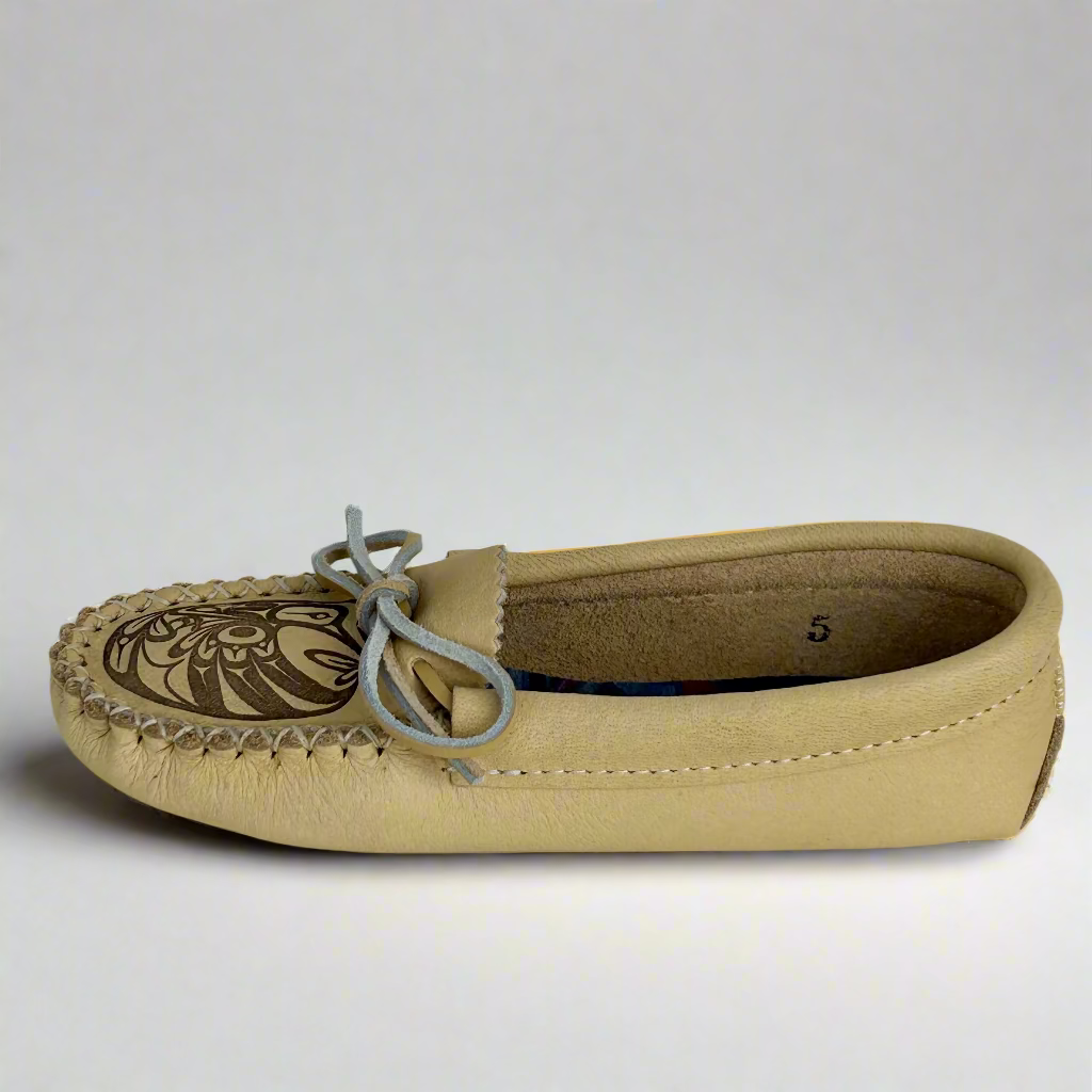 Beige moccasin shoe with a patterned sole on a white background