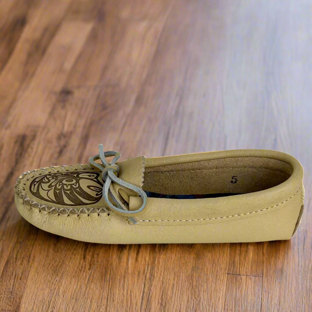 Beige moccasin shoe with a patterned sole on a white background