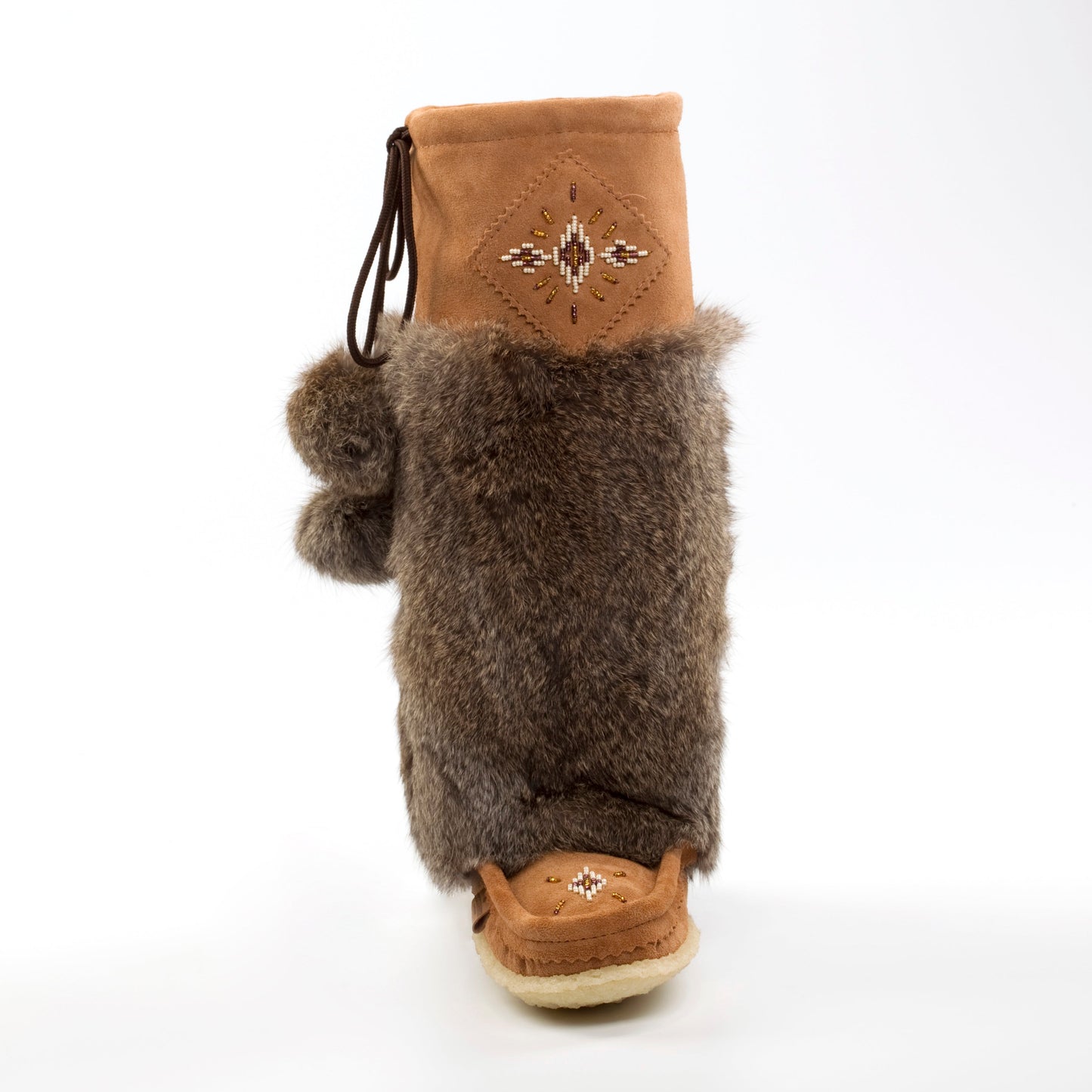 Brown furry boot with a decorative tag on a white background
