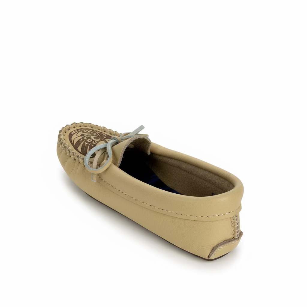 Beige moccasin shoe with decorative sole on a white background