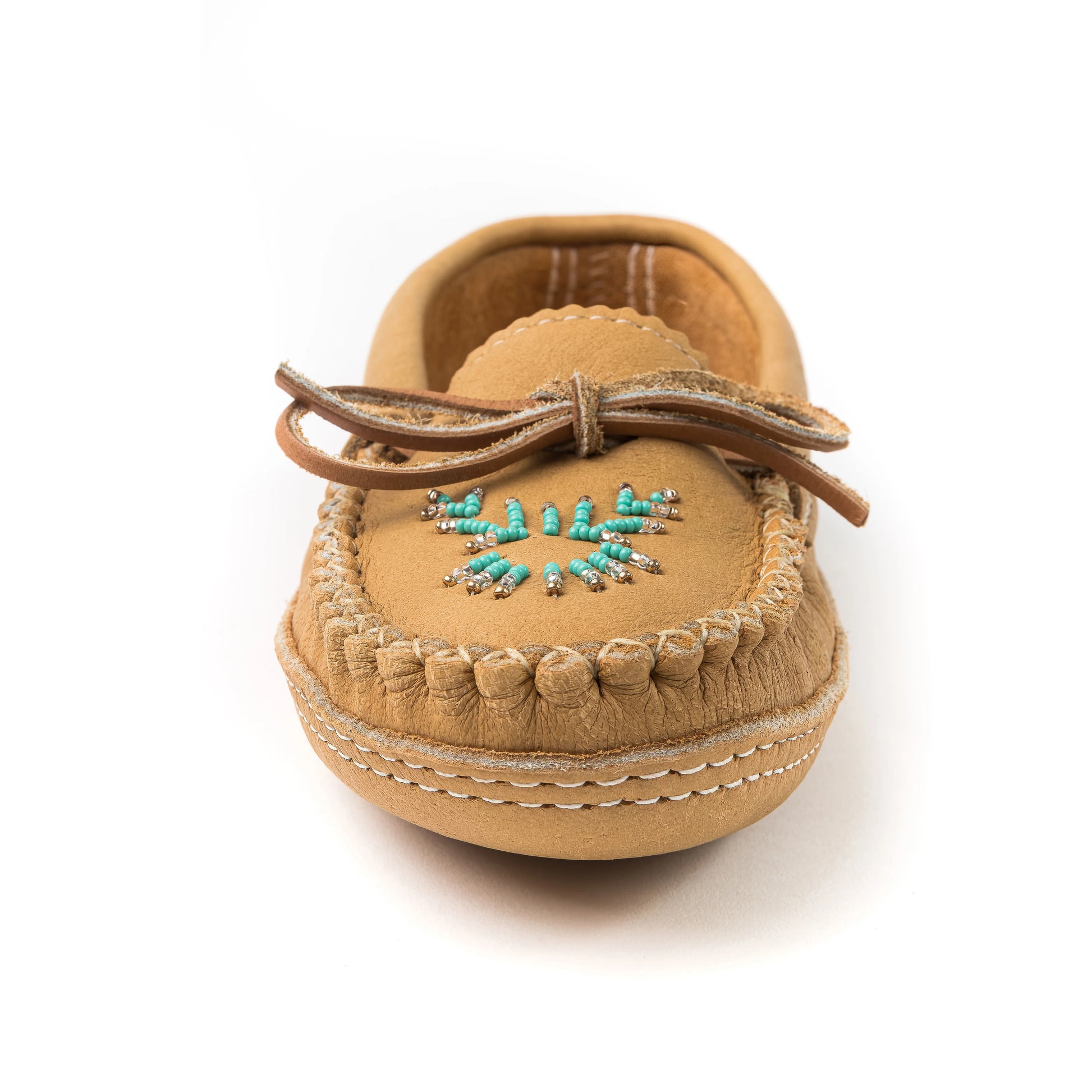Tan moccasin shoe with decorative elements on a white background