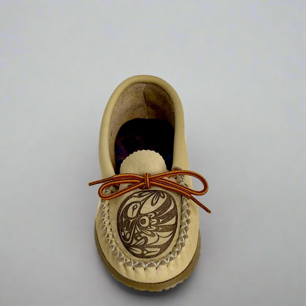Beige moccasin shoe with brown laces on a light gray background