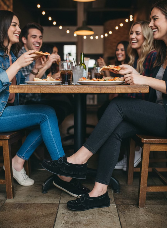 Black slip-on shoes with a brand tag on a white background