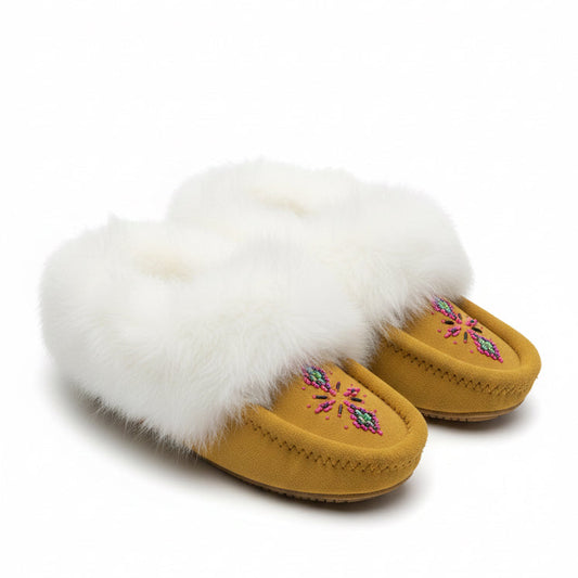 Pair of mustard yellow slippers with white fur and floral embroidery on a white background