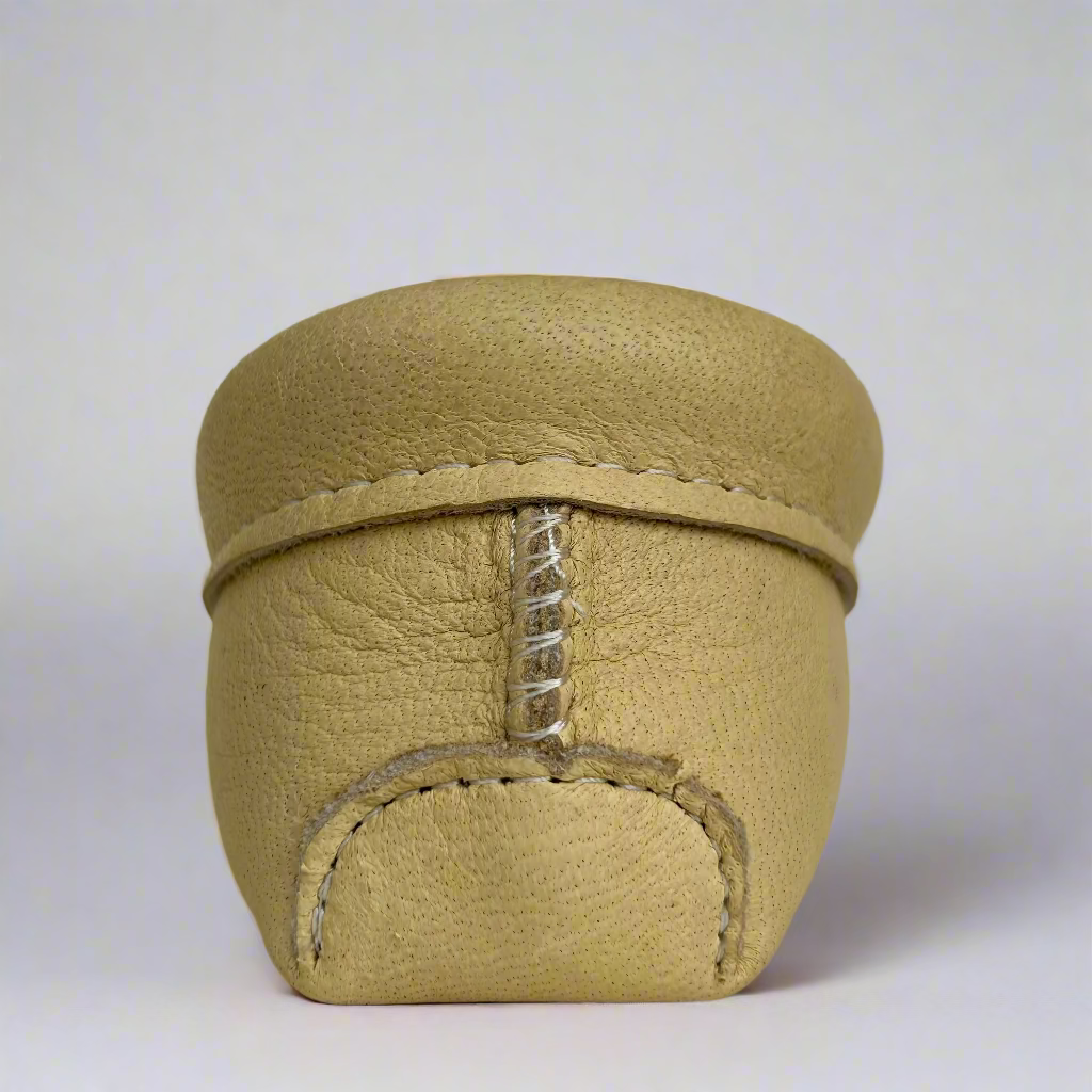 Beige leather shoe with stitching detail on a light gray background