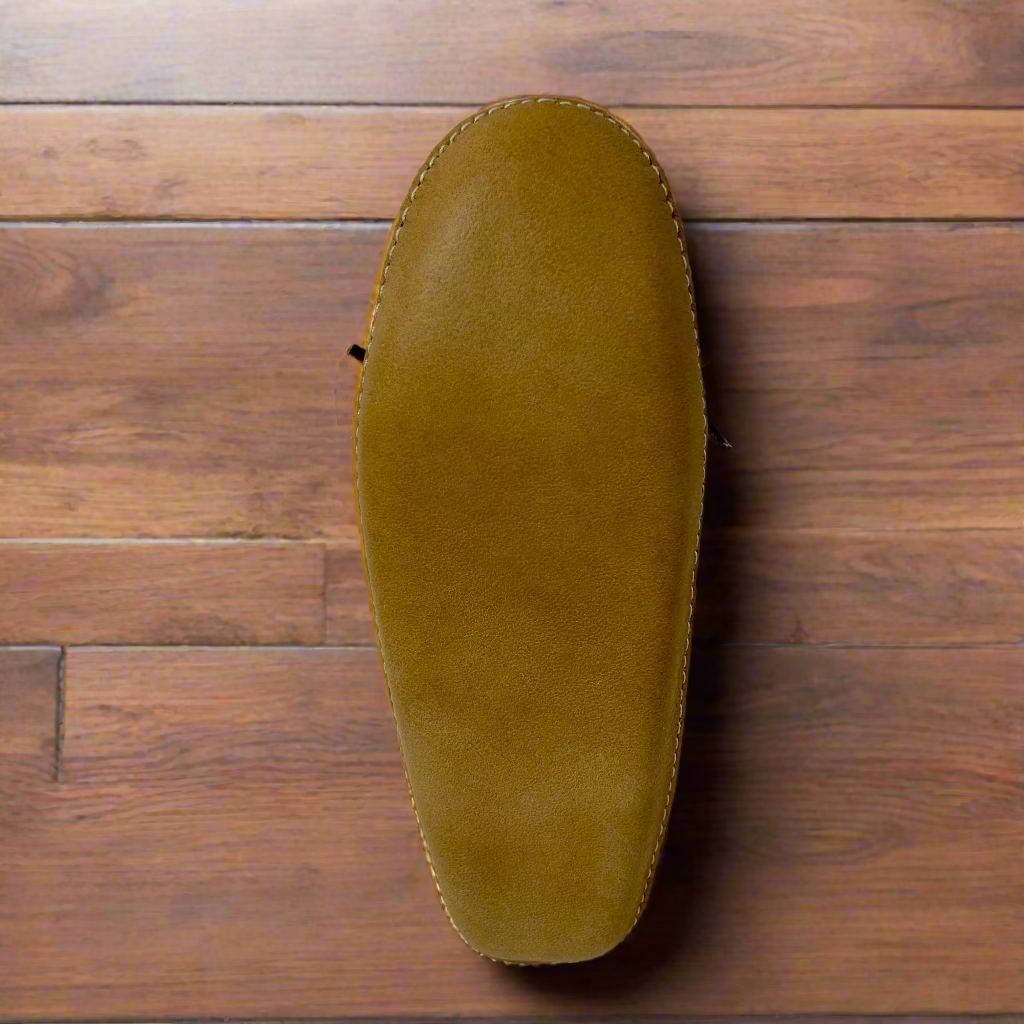 Brown leather shoe on a wooden surface