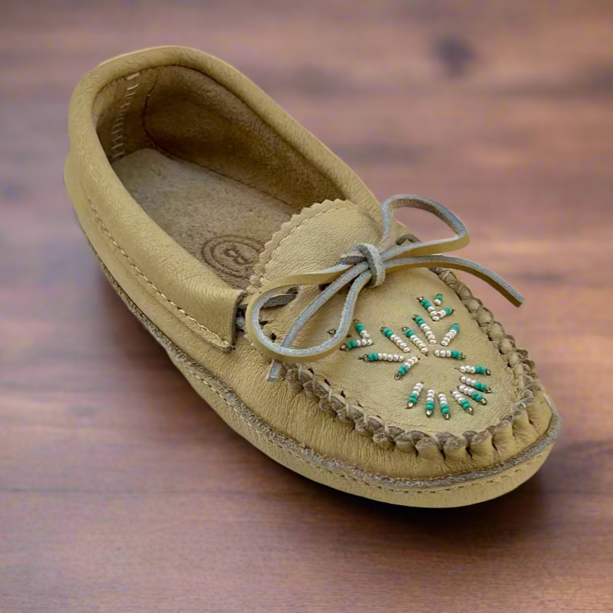 Beige moccasin shoe with decorative elements on a light background