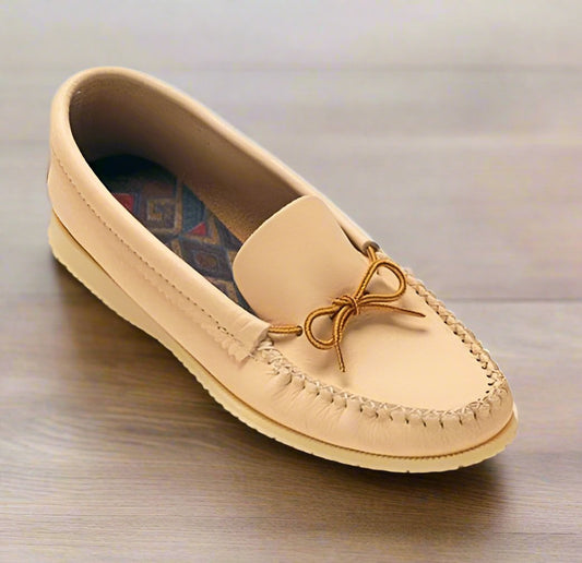 A beige men's moccasin with a double-padded insole and Indian rubber outsole, featuring a decorative bow on the top.