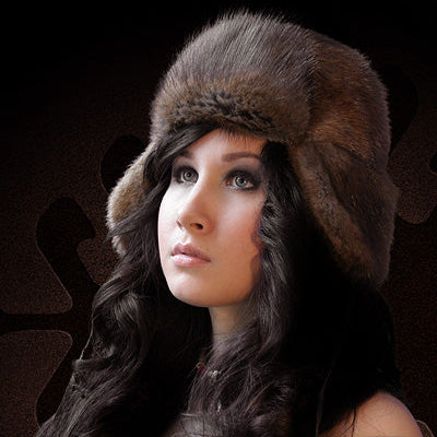 Woman wearing a brown fur hat against a dark background