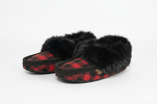 Pair of black and red checkered slippers with fur trim on a wooden floor.