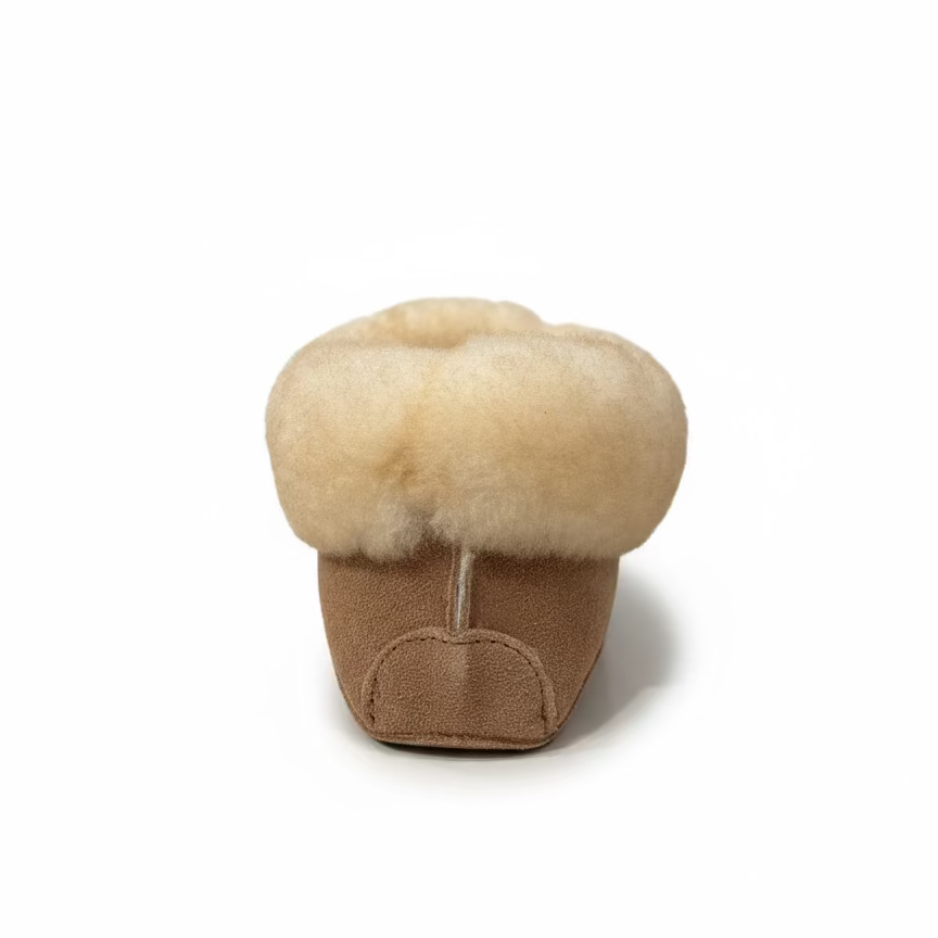 Small brown slipper with beige fur lining on a white background