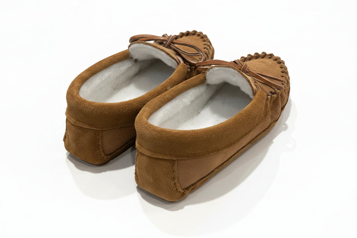 Pair of brown slippers on a light surface with a blurred background