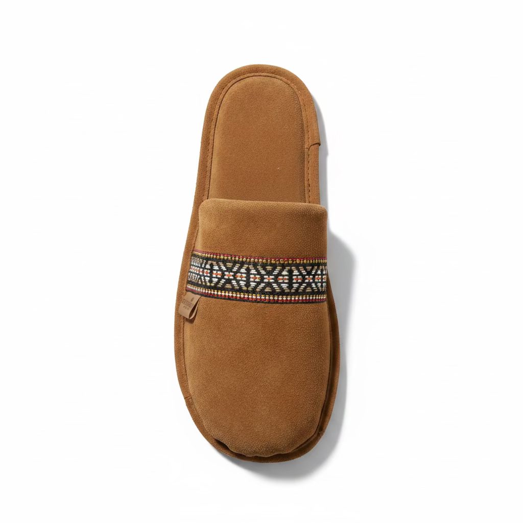 Brown slipper with a patterned strap on a light gray background