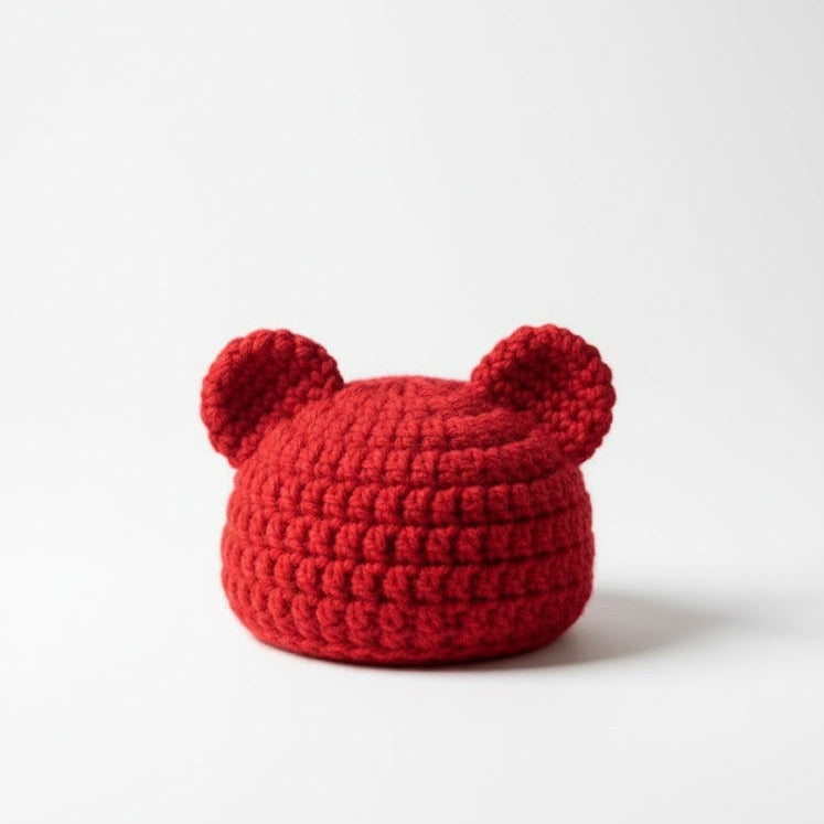 Red knitted bear hat on a white background