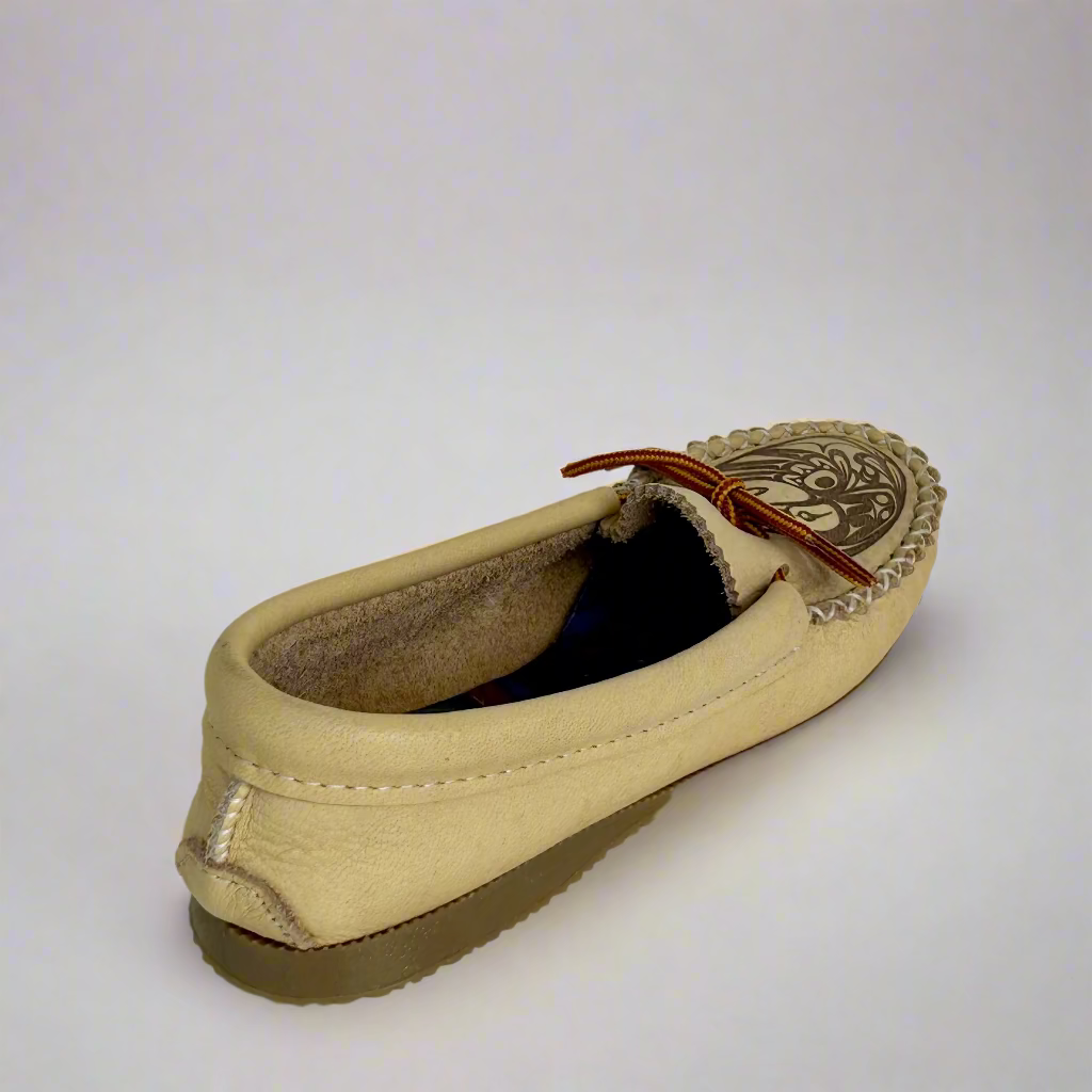 Beige slip-on shoe with decorative sole on a white background