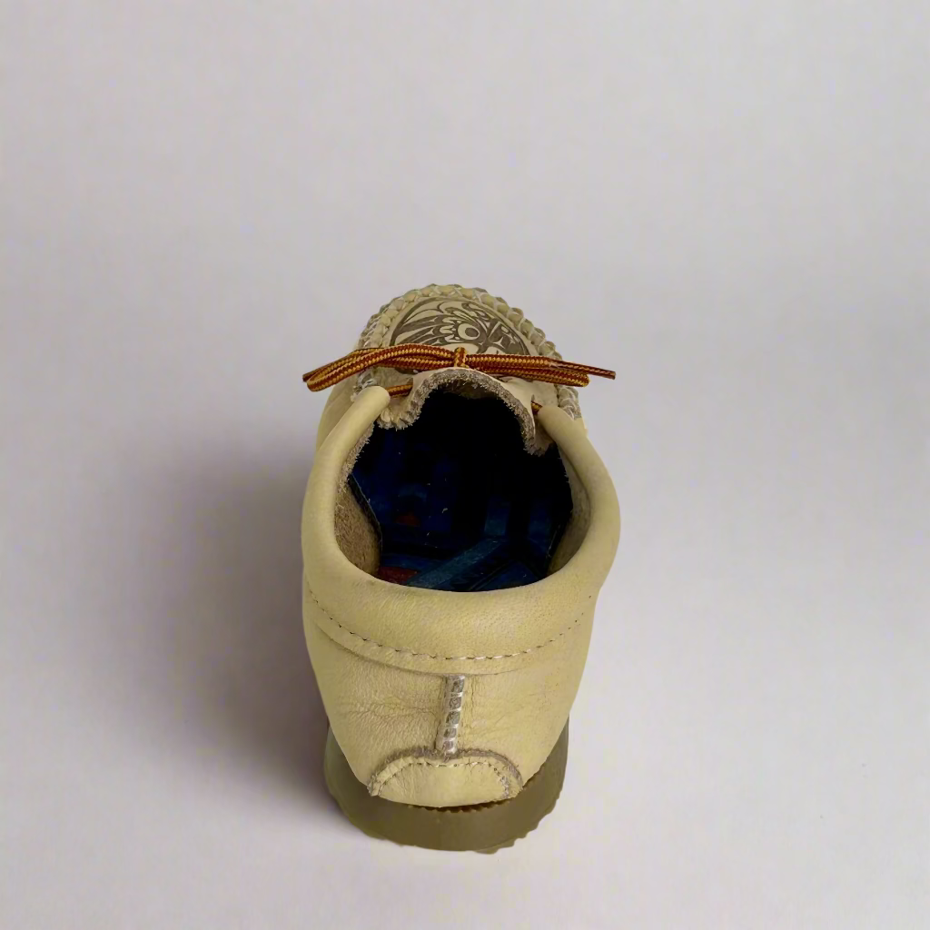 Beige driving shoe with a brown lace on a white background