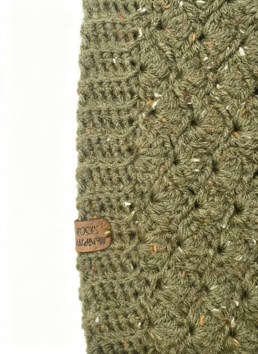 Close-up of a green knitted hat with a brand label on a white background
