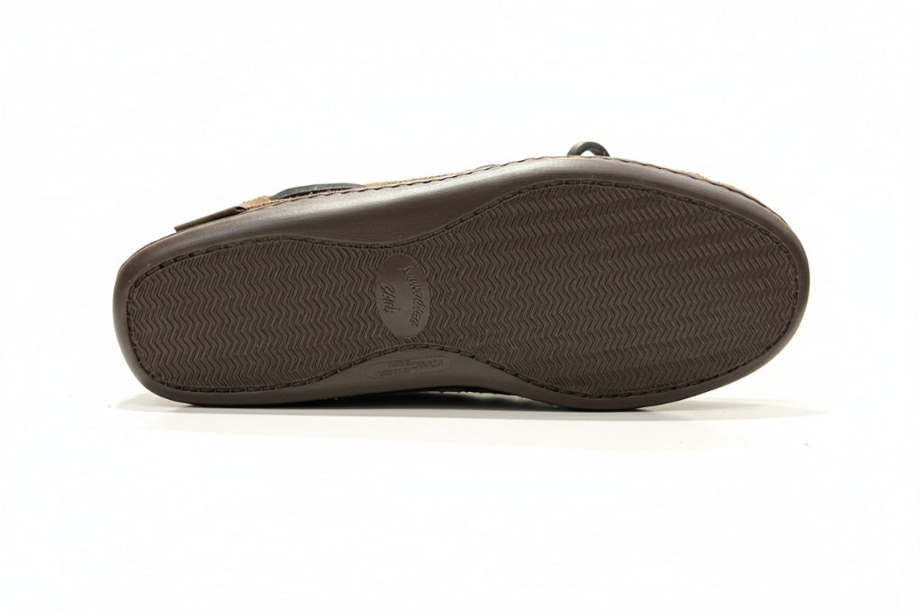 Brown moccasin sole with a textured sole on a white surface