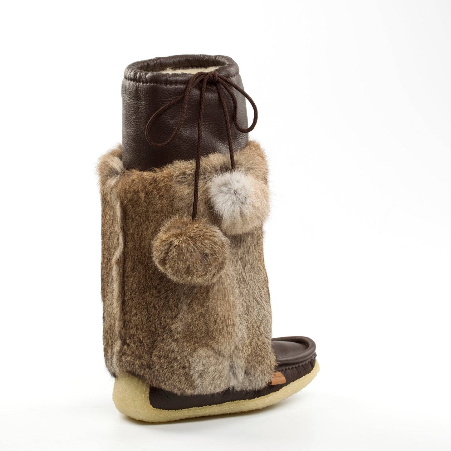 Brown fur boot with pom-poms on a white background