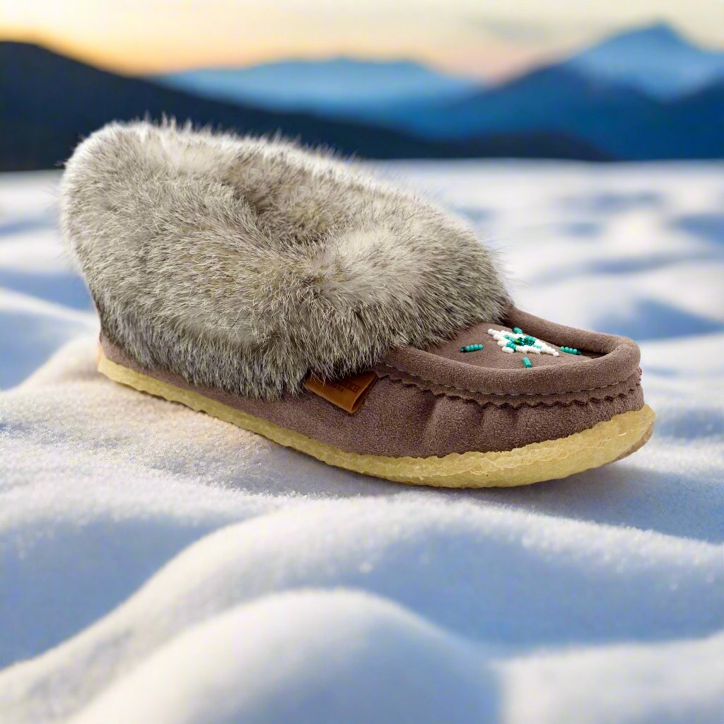 grey moccasin slipper with fur on a snowy surface