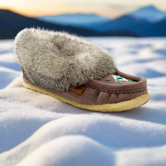 grey moccasin slipper with fur on a snowy surface