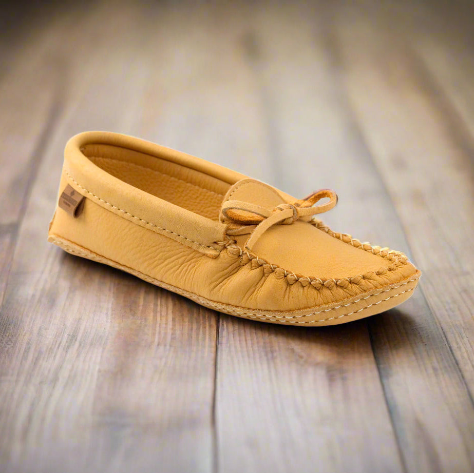 Yellow moccasin shoe on a wooden surface