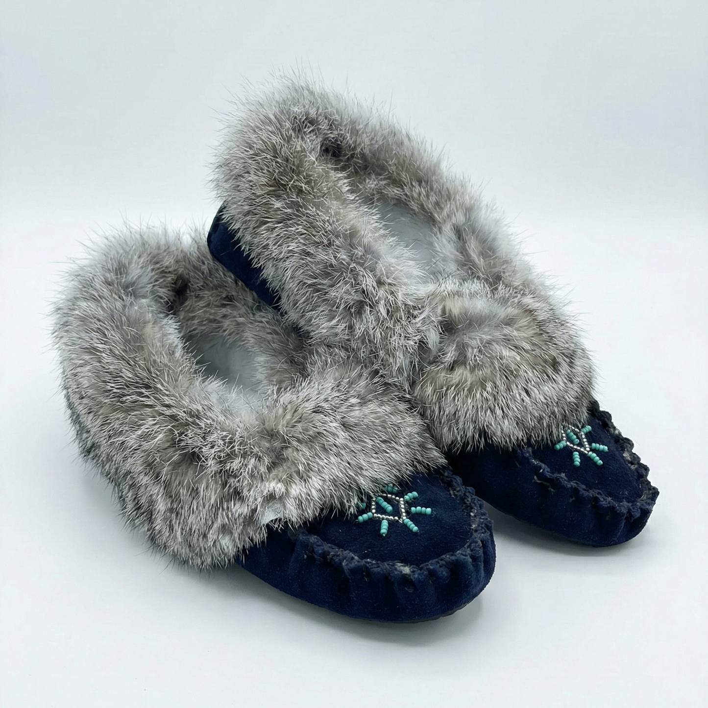 Pair of slippers with fur trim on a white background