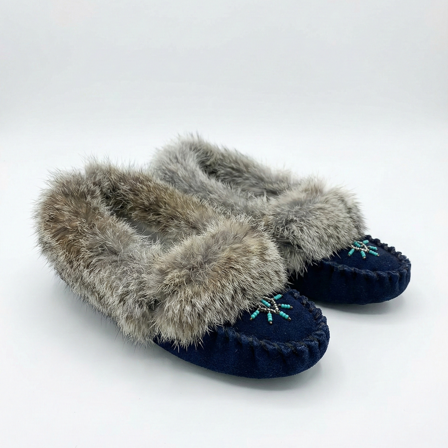 Pair of navy slippers with fur trim on a white background