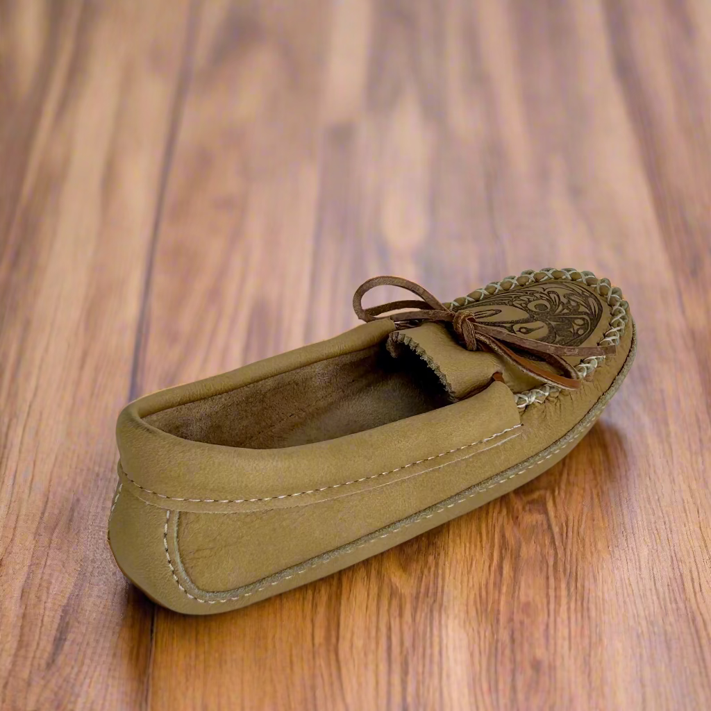 Brown leather shoe with decorative vamp on a wooden surface