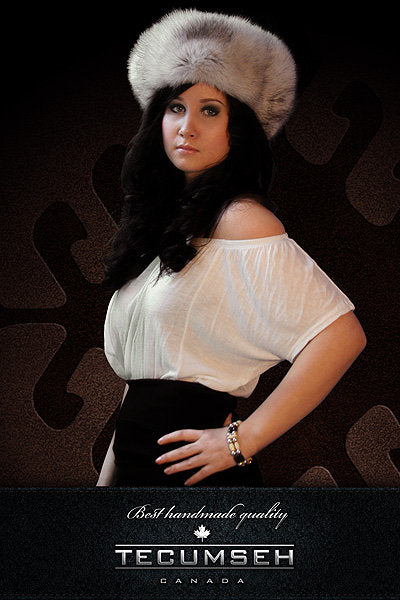 Woman wearing a white blouse and fur hat with 'Tecumseh Canada' branding.