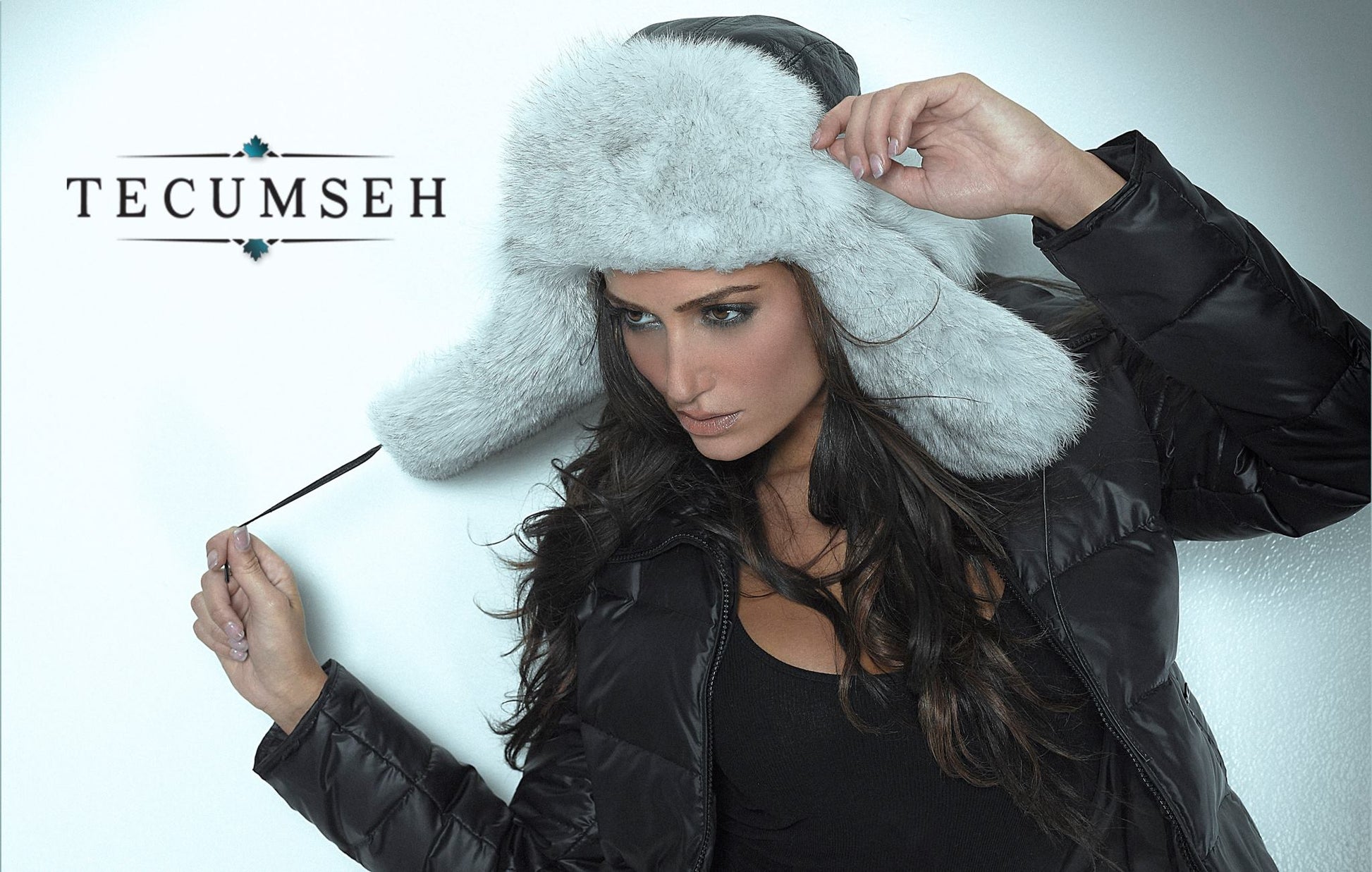 Woman wearing a white fur hat and black leather jacket with 'Tecumseh' branding.
