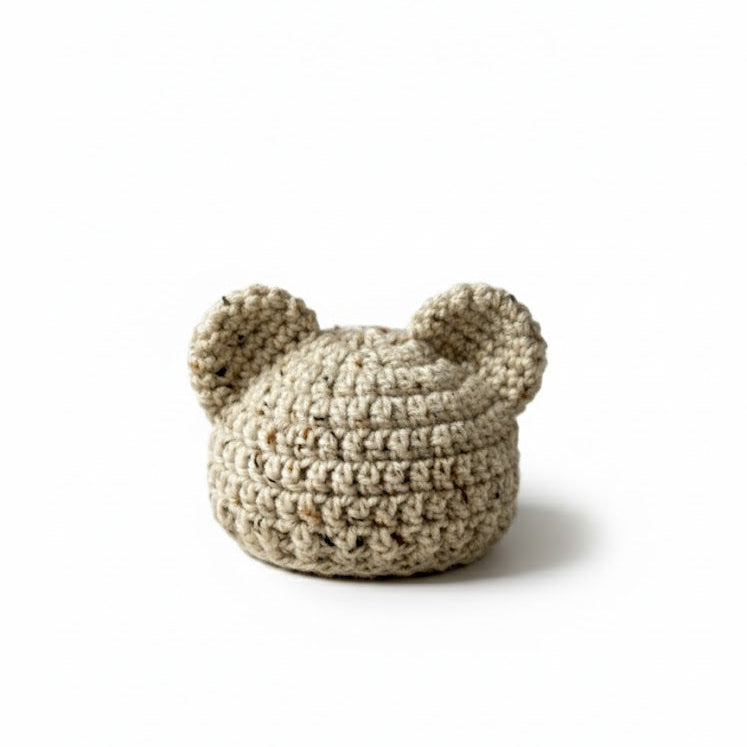 Crocheted beige cat hat with ears on a white background