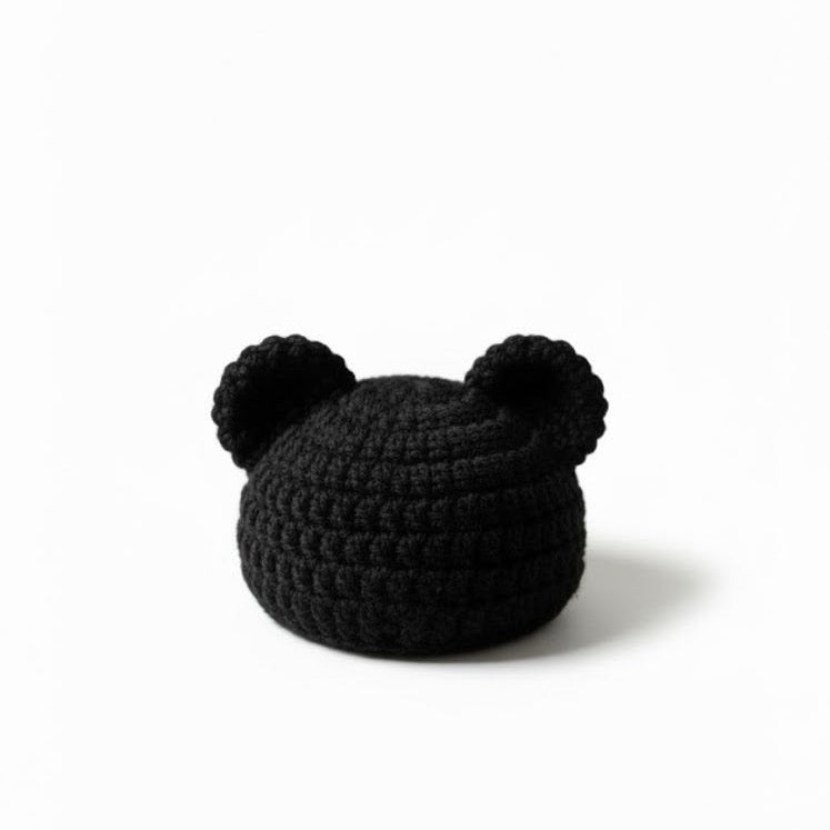 Black knit baby hat with on a white background