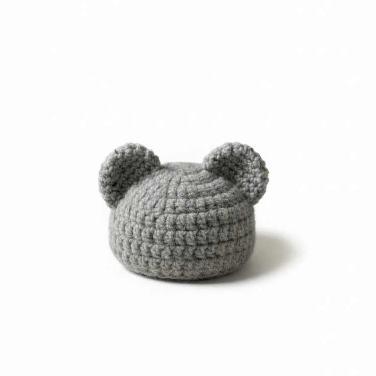 Gray crocheted beanie baby bear on a white background