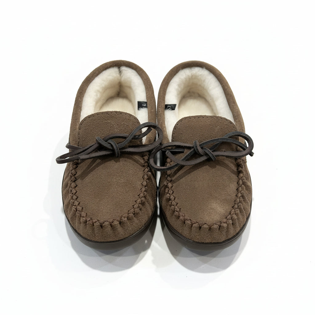 Pair of brown slippers with sheepskin lining on a light surface