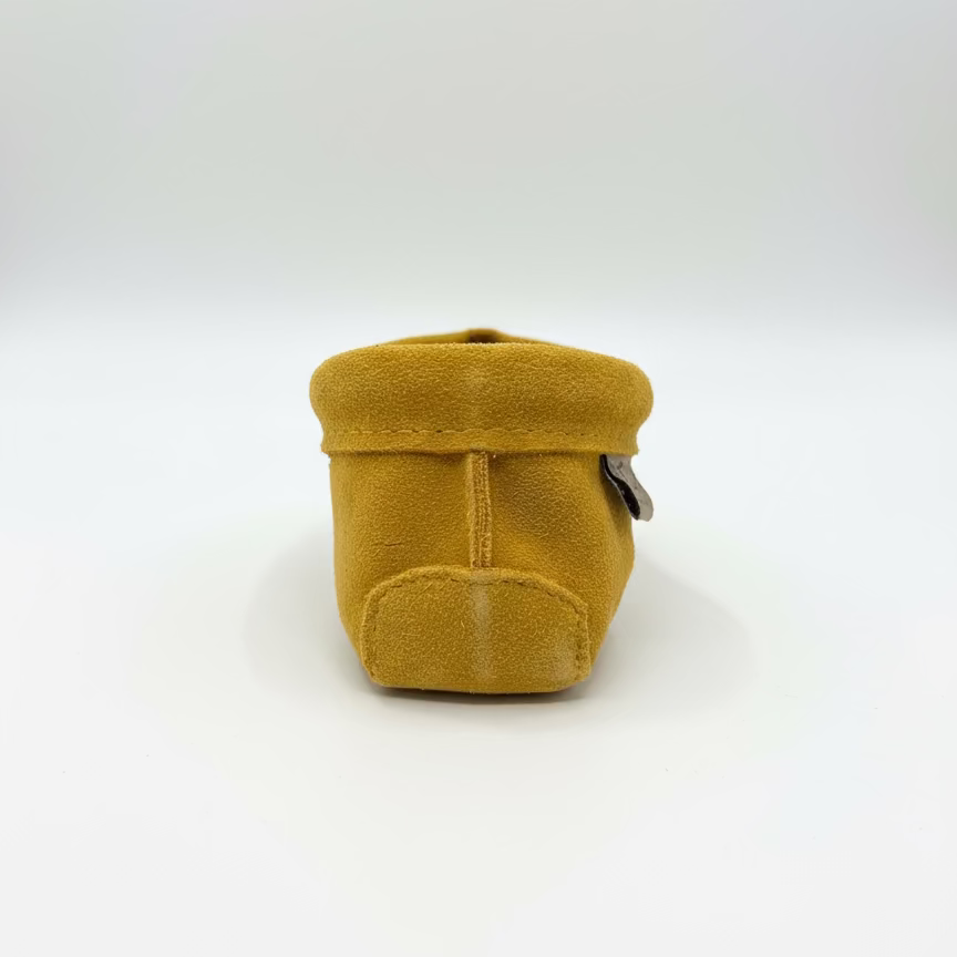 Mustard yellow suede shoe on a white background