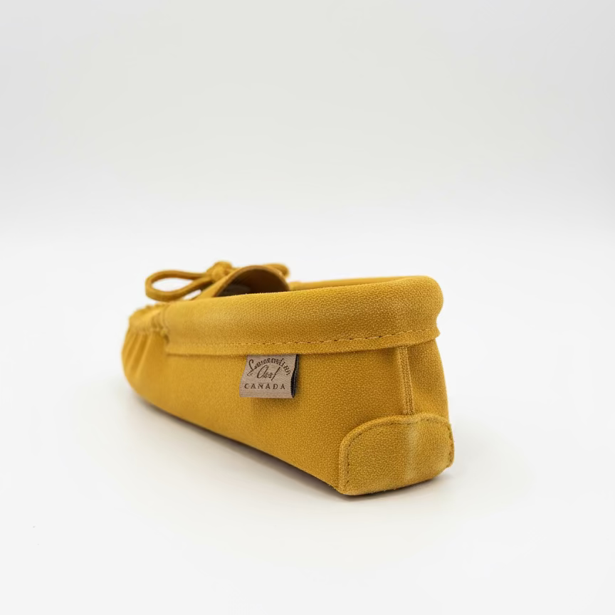 Yellow baby shoe on a white background