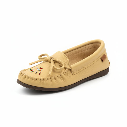 Beige moccasin shoe with colorful beads on a wooden floor